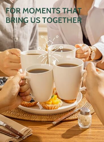 Group toasting with coffee mugs over pastries