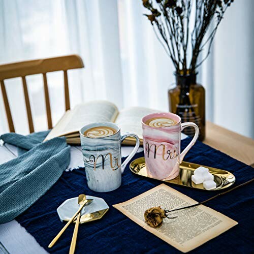 Two mugs with 'Mr' text, open book, and decorative items on a table