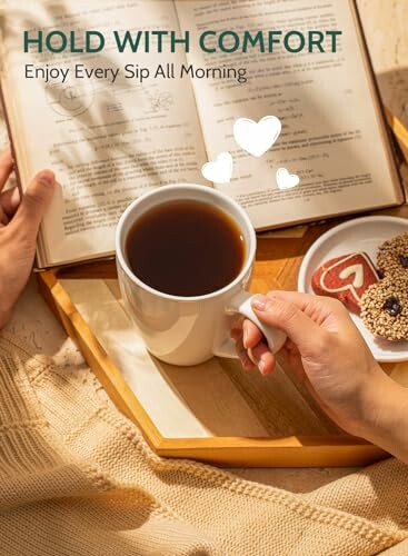 Person holding coffee cup with book and cookies on tray