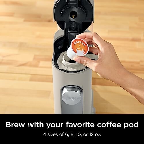 Hand placing coffee pod in Ninja coffee maker