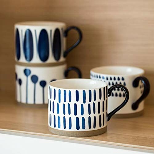 Set of ceramic mugs with blue patterns on a shelf.